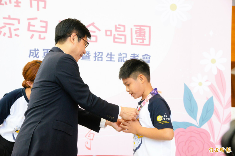 高雄市長陳其邁（左）為客家兒童合唱團成員一一掛上領巾。（記者許麗娟攝）