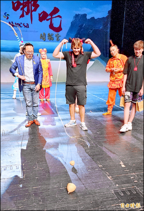 烏克蘭16歲青少年（右）會講流利英語，跟文總秘書長李厚慶（左）比賽擲陀螺後對他說，因為喜歡歷史，讀到台灣的國際政治現況，也因此次活動更認識且喜歡台灣。（記者凌美雪攝）