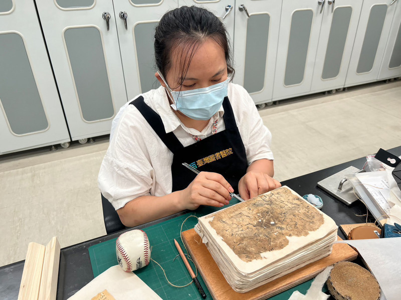 國台圖圖書醫院修復師徐美文仔細進行古蘭經修復工作。（國台圖提供）