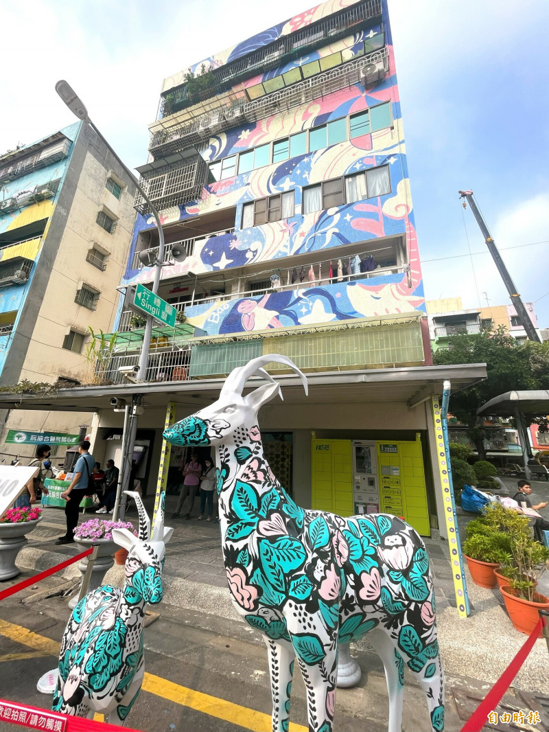 香港藝術家阿包6層樓高壁畫作品〈風之呢喃〉和羚羊作品。（記者許麗娟攝）