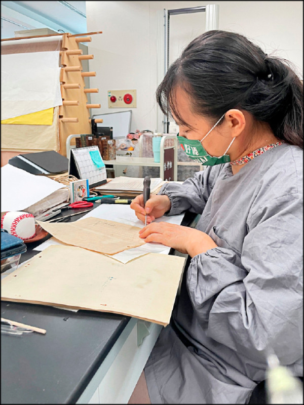 徐美文正在修復紙張，進行除鏽動作。