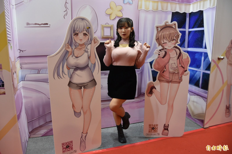 日本性感寫真女星天木純（中）投入VTuber（虛擬偶像）領域，來台參加第12屆台北國際動漫節，並與台灣人氣VTuber杏仁ミル（右邊立牌）一起聯名參展、推出限量周邊，與粉絲近距離互動。（記者吳柏軒攝）
