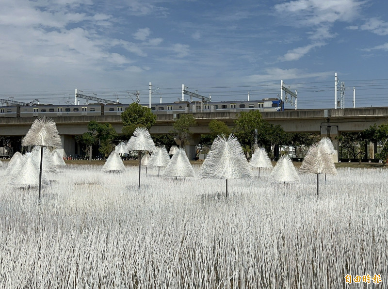 以藝術家游文富的作品《鹽田浮光》為前景，台鐵區間車從遠方穿越，別有一番迷人意境。（記者劉婉君攝）