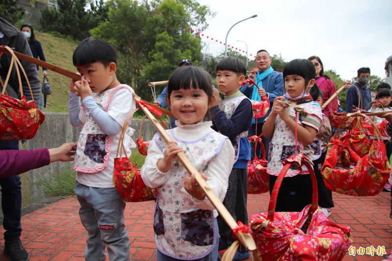 小朋友們領軍挑擔食福。（記者黃美珠攝）