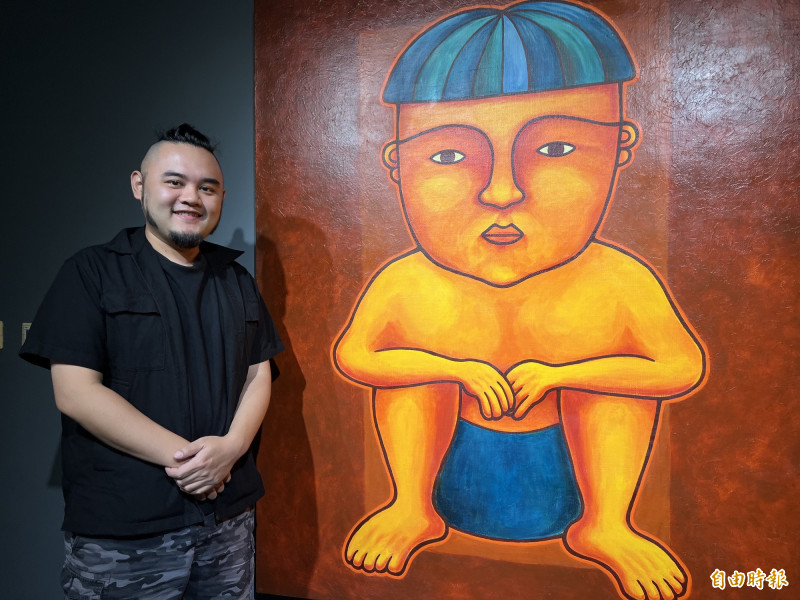 排灣族藝術家磊勒丹．巴瓦瓦隆和作品〈蹲坐的人〉。（記者羅欣貞攝）