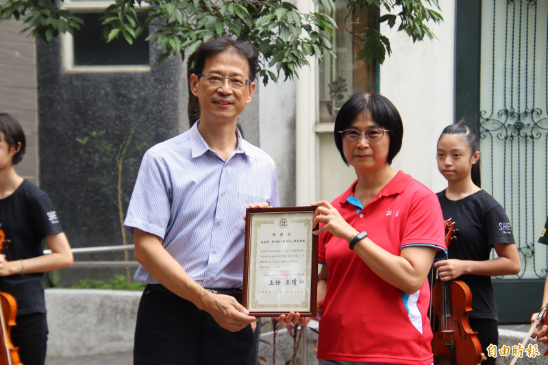 拙茁家園主任王瓊如（右）送上感謝狀，謝謝十興國小校長徐發斌率領十興國小弦樂團到家園分享音樂。（記者黃美珠攝）