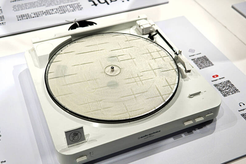 張博傑將黑膠唱片尺寸的窗花玻璃放到唱盤上去播，發現每種花紋的聲音都不同。（千北人攝）