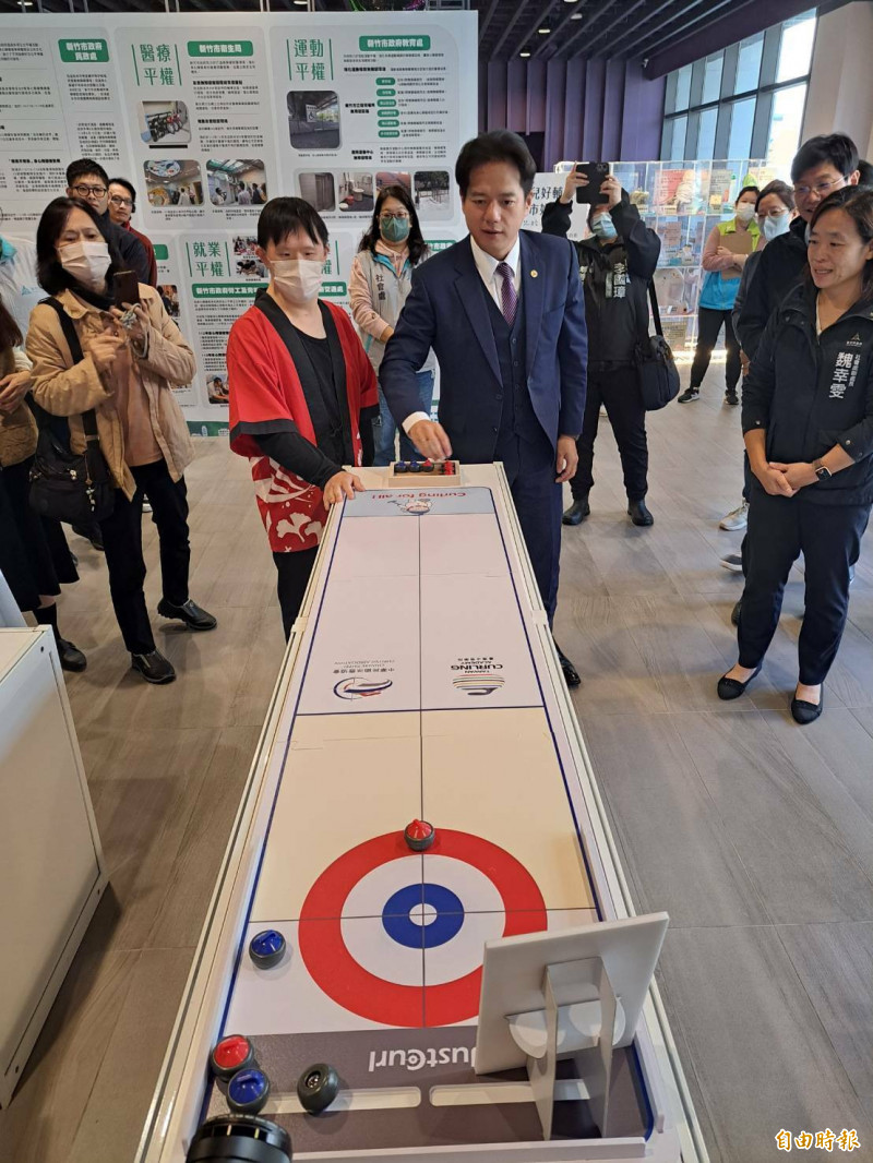 新竹市推動身心障礙者城市平權共好，代理市長邱臣遠也與身障者一起共玩冰壺運動體驗。（記者洪美秀攝）