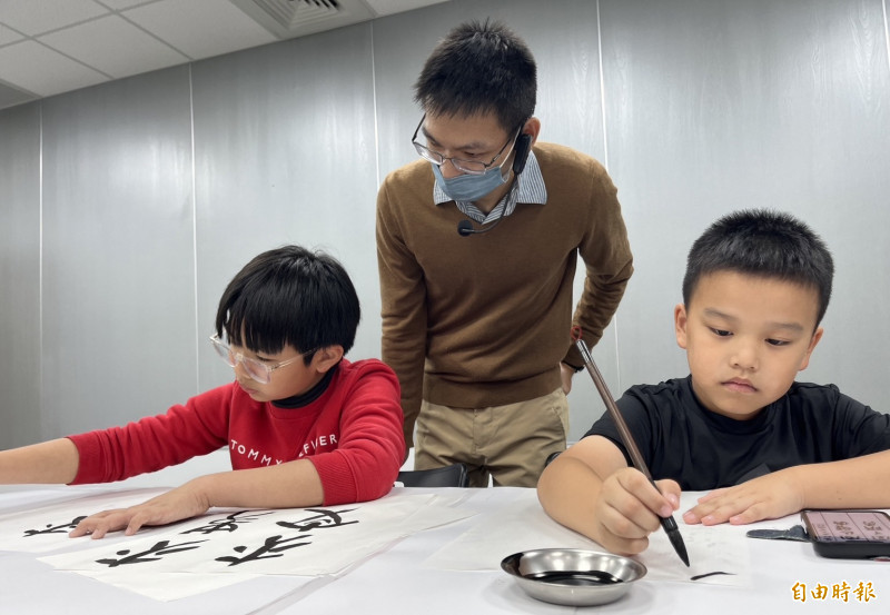 柯榆宏指導孩童學習書法。 （記者張軒哲攝）