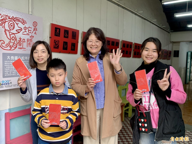 大秀國小校長黃琴（中）與師生以蛇年為題進行版畫創作，設計紅包袋。（記者張軒哲攝）