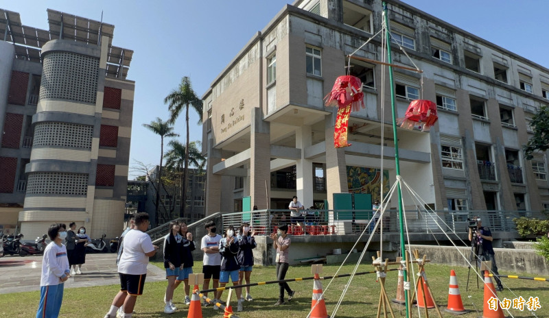 縣立大同高中國中部8年級彈性課程本週體驗創新尖炮城，學生用沙包丟中炮籠，春聯就會落下來，喜氣十足。（記者羅欣貞攝）