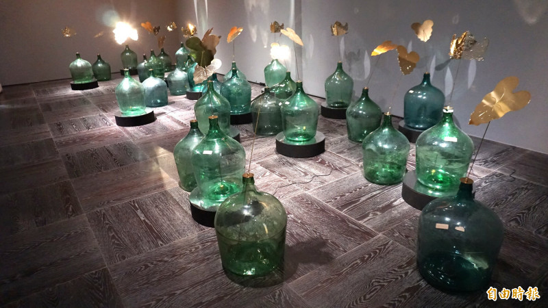 陳漢聲〈兩個太陽——菱角？芋頭？〉以蒸餾水玻璃瓶與金屬片構成，投射人造地景的靜默歷史。（記者董柏廷攝）