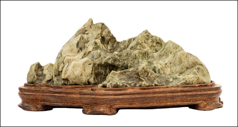 此件山形戈壁石，似一座陡峭的山嶺，通體為玉化的綠碧石，造形壯闊美麗，山石表面紋理細膩有加。17×6.3×6.2公分。