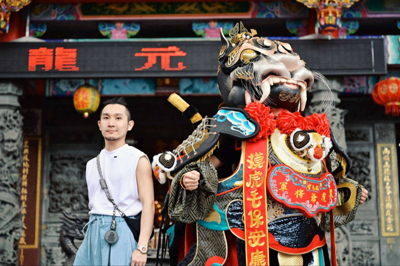 塑神藝術家李育昇（左）與由他和設計師廖小子聯手打造的「電氣黑虎爺」合影。作品融合黑翅、虎紋與火金工藝，展現傳統信仰與當代設計交會的創新美學。（陳安嘉攝，洄游創生提供）