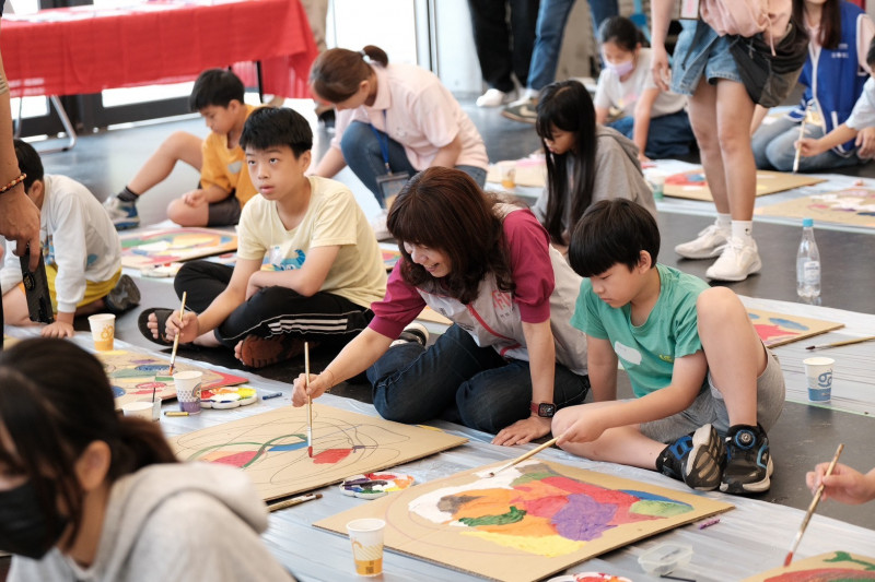 青年志工與孩童一起透過水彩和壓克力顏料進行創作。（桃市青年局提供）