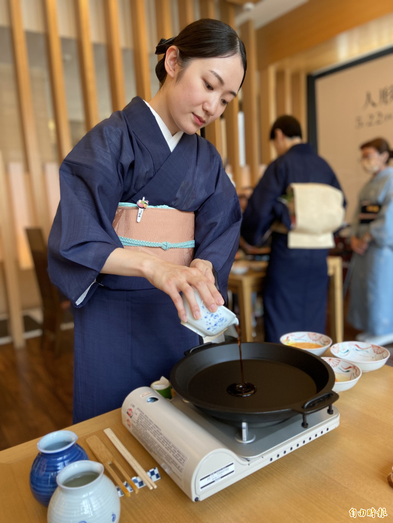 來自人形町本店的服務人員根本菜水香，涮煮前先倒入人形町今半壽喜燒的靈魂醬汁。（記者周幸叡攝）