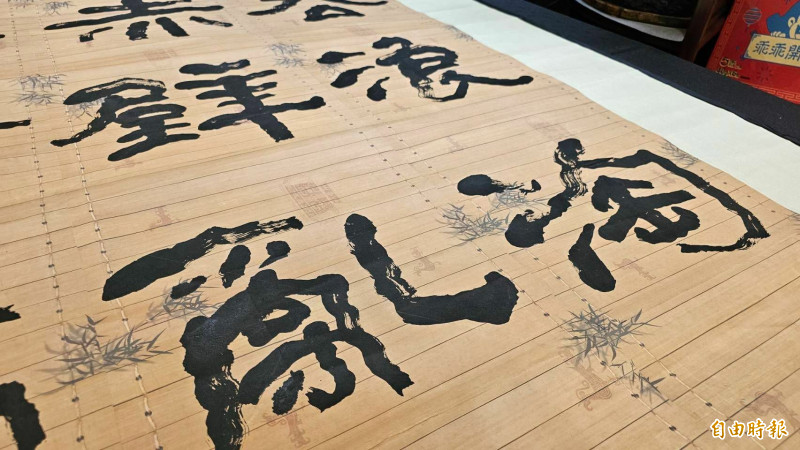 吳肇勳選用仿古竹簡宣紙來寫下超大書法作品。（記者劉曉欣攝）