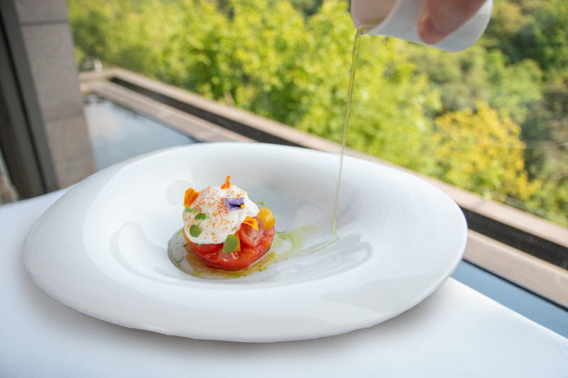 「番茄布拉塔乳酪甜蘿勒」選用梅子醋漬的牛番茄與彩色小番茄，內餡包覆布拉塔起士。（北投麗禧溫泉酒店提供）