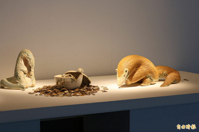 《破籠子》描繪一隻鱗片細緻、色澤溫潤的穿山甲，正從陶罐中緩緩探出身軀，卻被生鏽鐵籠束縛其間。（記者陳奕劭攝）