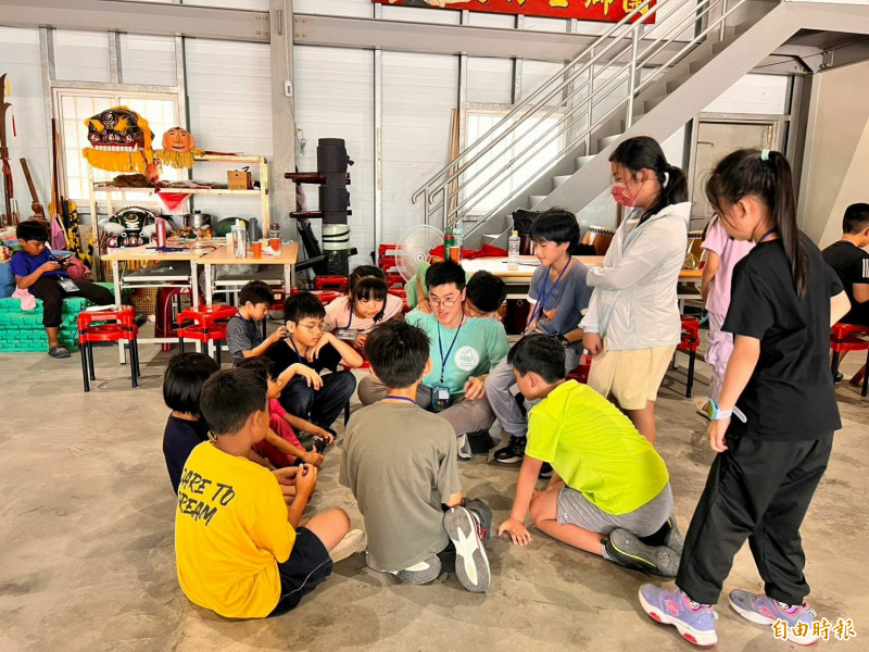 學員們聚精會神聽營隊哥姐們講客家方口獅的源起。（記者黃美珠攝）