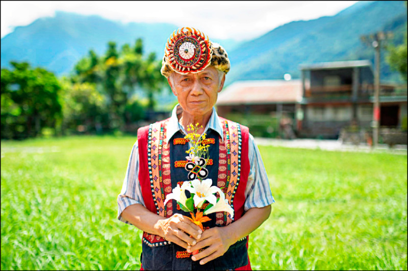 魯凱族耆老包達夫手持部落中象徵最高榮譽的百合花頭飾，他在部落中備受尊崇，被稱為「獵王」。（林彥廷攝，報導者提供）