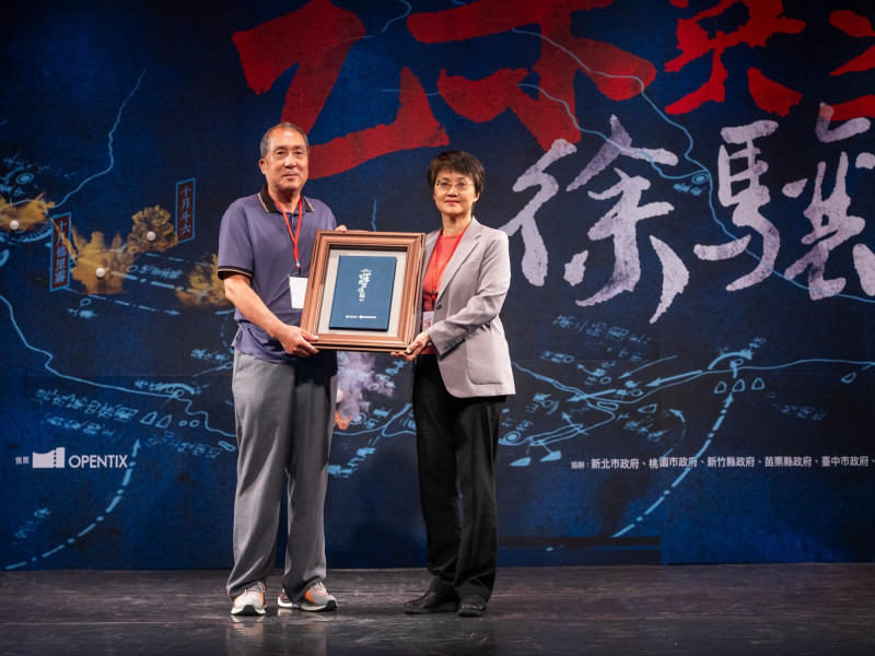 客委會主委古秀妃向徐驤烈士後代，曾孫徐永康致贈《1895乙未英烈－徐驤》劇本。 （客委會提供）