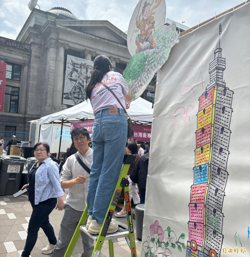 有義工正在為台灣地圖塗上顏色。（記者張伶銖攝）