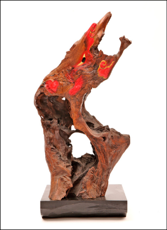 施鎮洋利用木頭原有的形勢，畫龍點睛的巧雕作品〈鳳鳴〉。