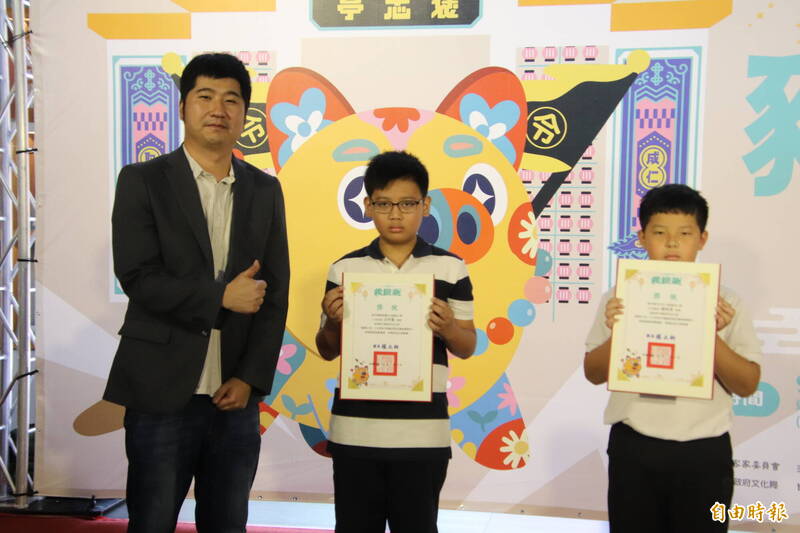 客委會副主委邱星崴（左起）頒獎給彩繪神豬優選得主石光國小沈宇豪、十興國小楊侑澄。（記者黃美珠攝）