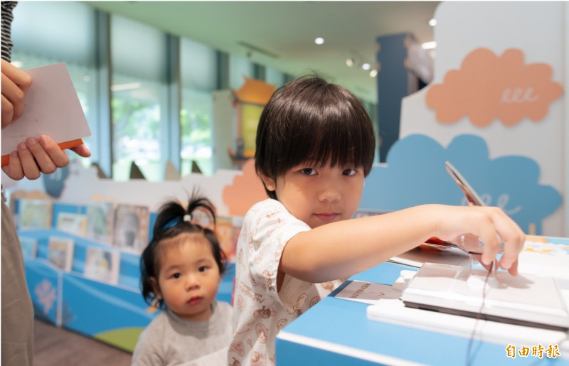 親子在每一洲要完成這個明信片套印，走完五大洲，就會將明信片完成，是一個紀念，也是完成環遊世界的夢想，可以寄給自己或家人。（記者李容萍攝）