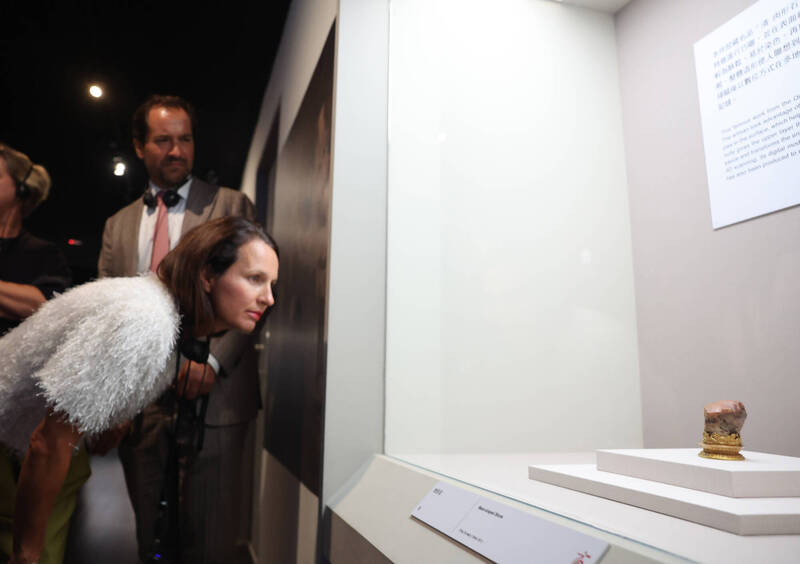 國立故宮博物院歡慶百年，20日在台北舉行「故宮100+院慶暨特展聯合開幕晚會」，並帶領與會眾人走訪展間，外籍來賓仔細觀賞鎮院之寶「肉形石」。（趙世勳攝，中央社提供）