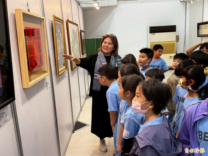 江敏英為學生導覽參展作品。（記者洪臣宏攝）