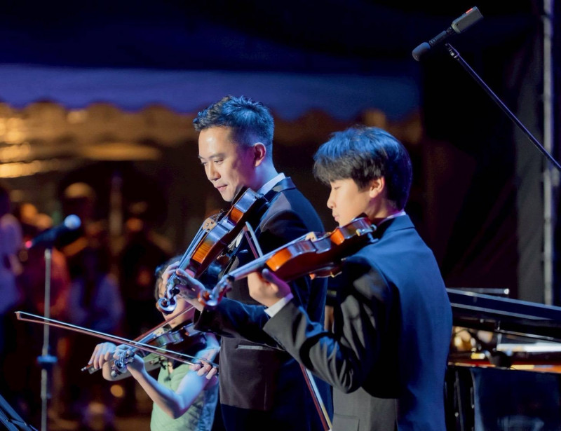 竹北市場鄭朝方（左）偕同21位市民學生與理查同台合奏《凡妮莎的微笑》。（竹北市公所提供）