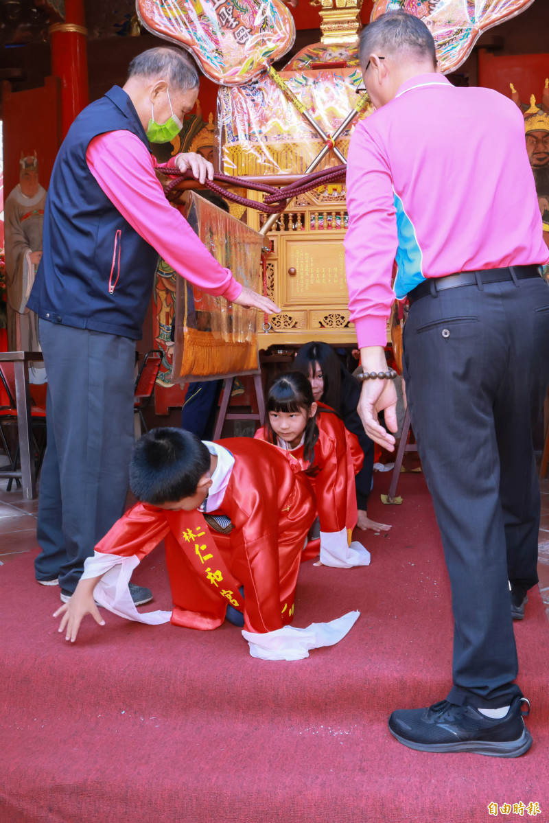 學生們排隊鑽轎腳，接受媽祖祝福。（記者陳冠備攝）