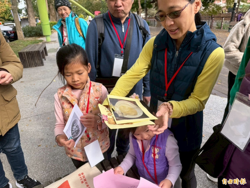 參加活動者拿著食材圖案組拚客家菜。（記者黃美珠攝）