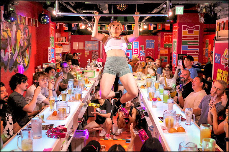 東京筋肉女子酒吧的店員表演引體向上。（路透社提供）
