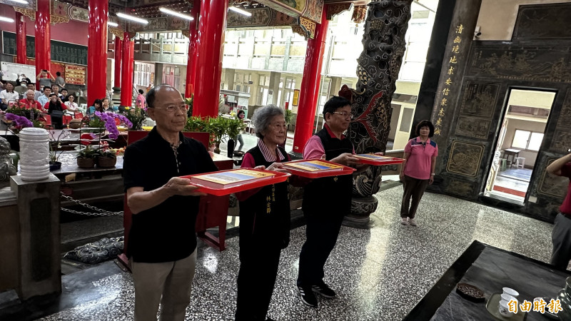 《佳里昭清宮志》主要作者許献平（左起）、昭清宮主委林金節、常務監察莊文中，代表將新書獻給恩主公。（記者劉婉君攝）