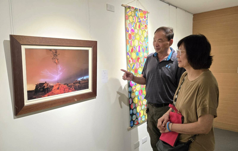 台南市藝術家協會理事長葉明吉（左）為觀眾解說藝術家作品。（新營文化中心提供）