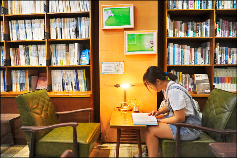 城鄉潮間帶書牆前的綠皮老沙發。