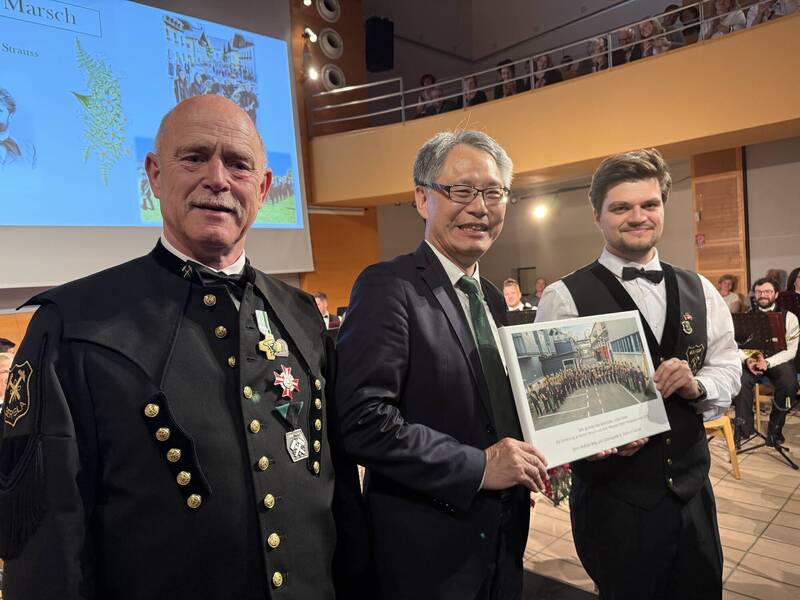 聖馬丁鎢礦管樂隊團長Sommer  Karl-Heinz（左）與團隊代表共同致贈團隊大合照給劉玄詠（中）。（駐奧地利代表處提供）