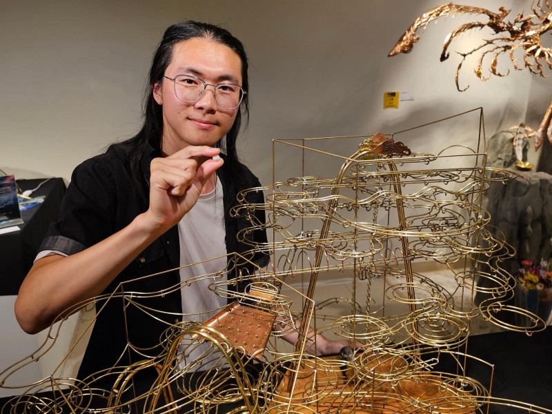 「學生傅呈祐以黃銅、紅銅與回收木材創作裝置作品《遷行》」