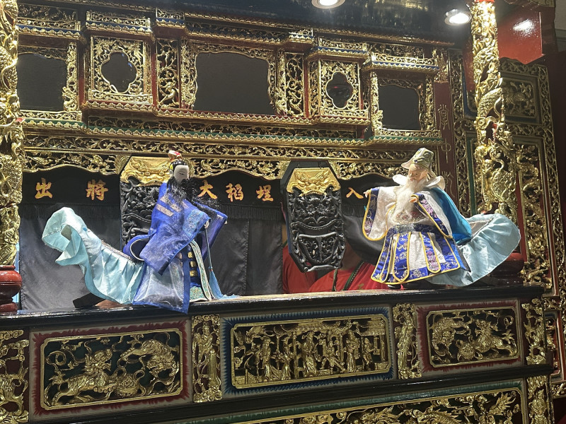 劇中靈隱寺法術辯論場景，雙方於華麗木雕彩樓前展開道法交鋒，戲偶身段張力十足。（台北市藝文推廣處提供）