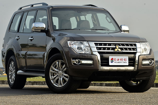 2015年式三菱Pajero 5門款換上新款鍍鉻水箱護罩與結合LED晝行燈的前保險桿，搭配金色三菱廠徽，車頭視覺感更顯氣派華麗。