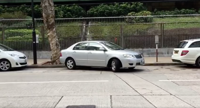 開著銀色房車的女駕駛準備停車的路邊，空間相當大，然而這卻沒讓他一次停好車。