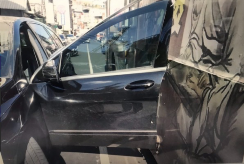 駕駛賓士休旅車的吳姓女子，一開車門遇到強風，被剛起步的公車撞上，車門變成反折。（記者吳仁捷翻攝）