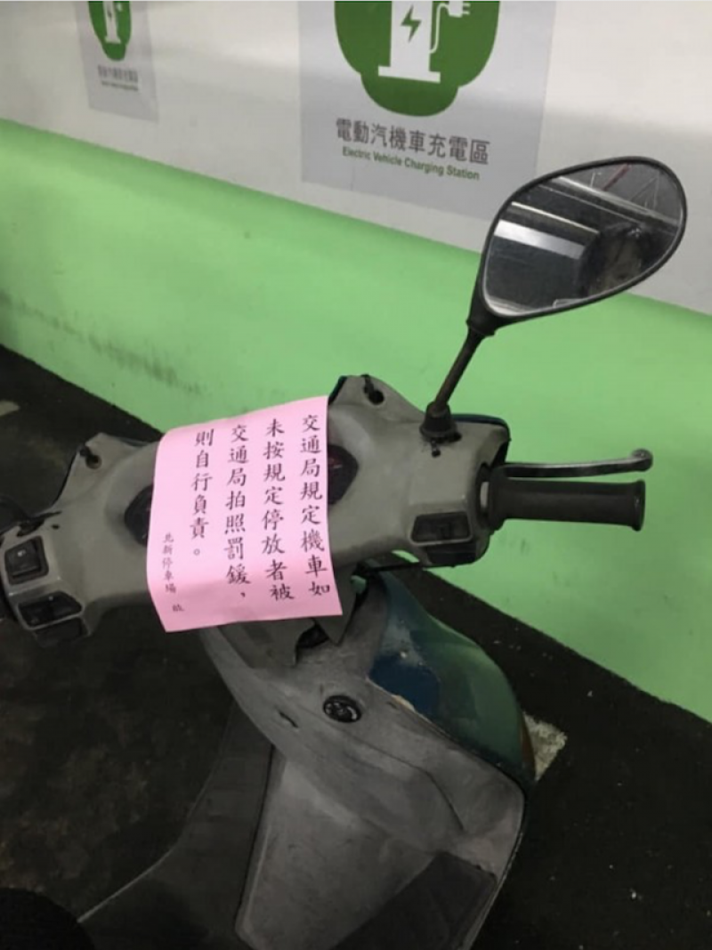 一名網友抱怨機車停在停車場，竟遭員警開單，不過其他網友在看過原 PO 附上的照片後，才發現是該台被開單機車是停放在「電動汽機車充電區」。（圖擷取自爆廢公社）