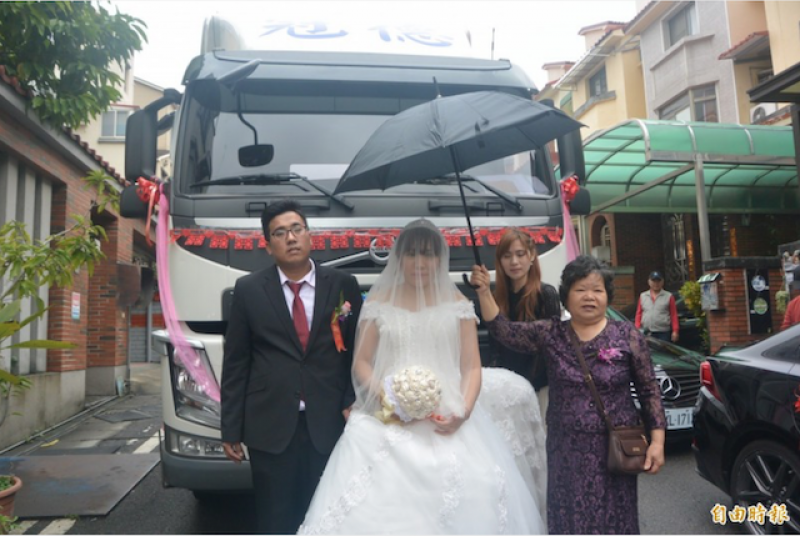 貨車司機李冠儒（左）用 6 輛拖車頭迎娶，給新娘梁韻晴（左二）「不一樣」的婚禮。（記者張勳騰攝）