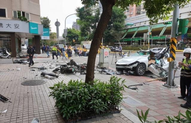一輛白色休旅車上午 9 時許衝撞建國南路一段旁的人行道，掃倒路邊多輛機車。（記者姚岳宏翻攝）