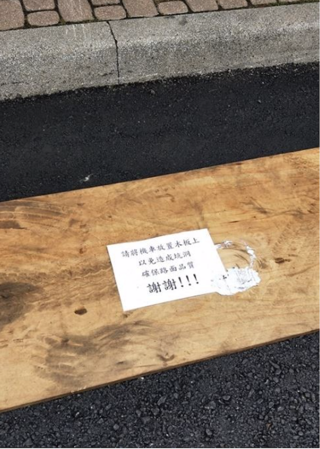 工務處養護工程科長黃治錦回應，在畫有機車格的區域上擺置木板是同仁的小巧思，一來可以保護新鋪的路面不會遭受到機車柱的破壞，再者也可以確保民眾的機車不會沾到瀝青。（圖擷自臉書）