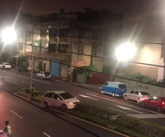 原 PO 貼出卡在分隔島的白色汽車，網友看到貼文後群起吐槽。（圖擷自爆料公社）